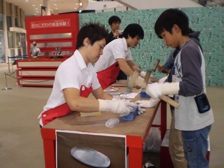 板金作業の体験。会場内には子供たちの槌音がひびいていた