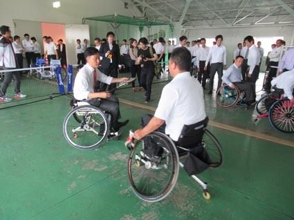橘さんから車いすテニスの説明を受ける小野社長(左)