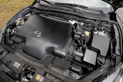 2.0リットルの「スカイアクティブ―X」を搭載した開発車両。大きなエンジンカバーで放熱や騒音を抑制する