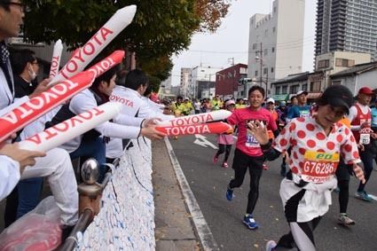 トヨタのロゴ入り応援グッズでランナーに声援を送った