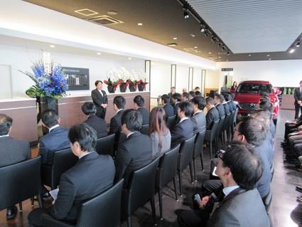 ショールームでの記念式典で挨拶する菊地社長