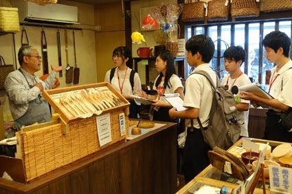 商店の経営者らに街の歴史をインタビュー