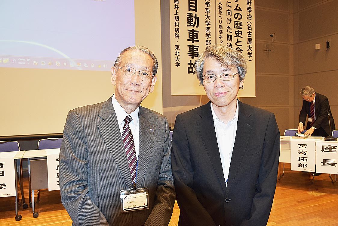 第55回総会・講演会会長の南多摩病院・益子邦洋院長(左)が、次回会長の名古屋大学大学院・水野幸治教授にエールを送った