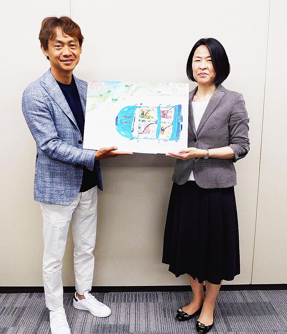 ワクドキ賞「運転を楽しむ車」(髙橋恒佑/日本、8歳)を持つレーシングドライバーの脇阪寿一氏(左)とトヨタガズーレーシングカンパニーの大塚友美エグゼクティブバイスプレジデント