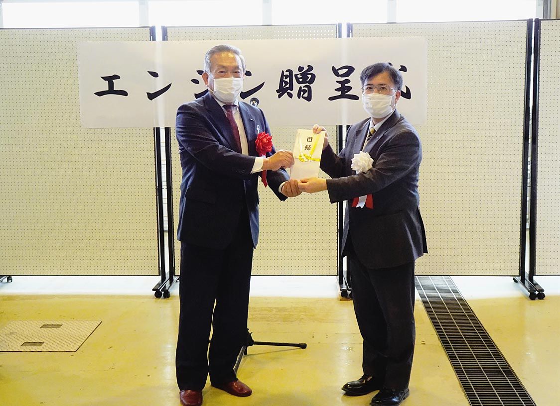 (左から)吉泉社長から髙橋校長へ目録が手渡された