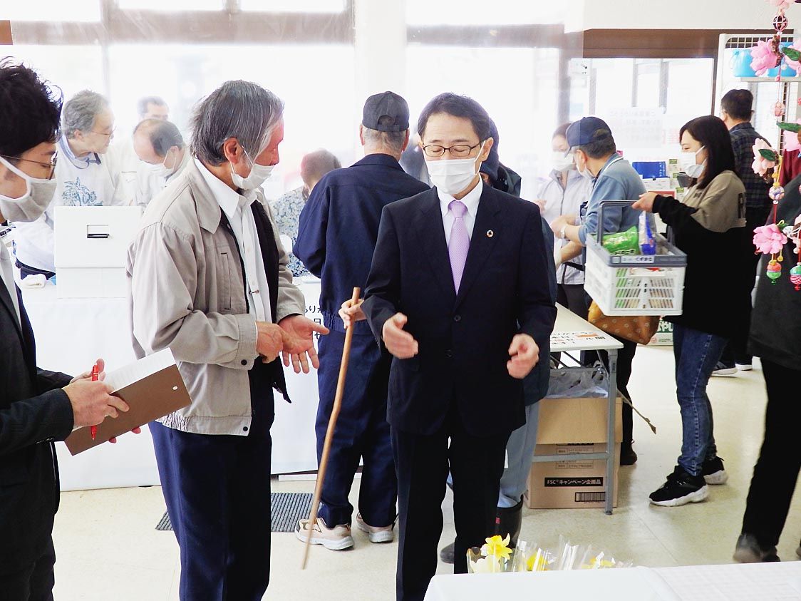 買い物客でにぎわうくずまきスーパー。説明を受ける山本執行役員(中央)