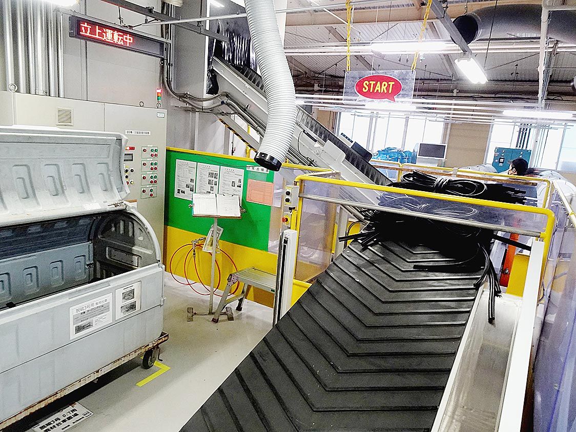 端材はベルトコンベアで破砕機へと向かう