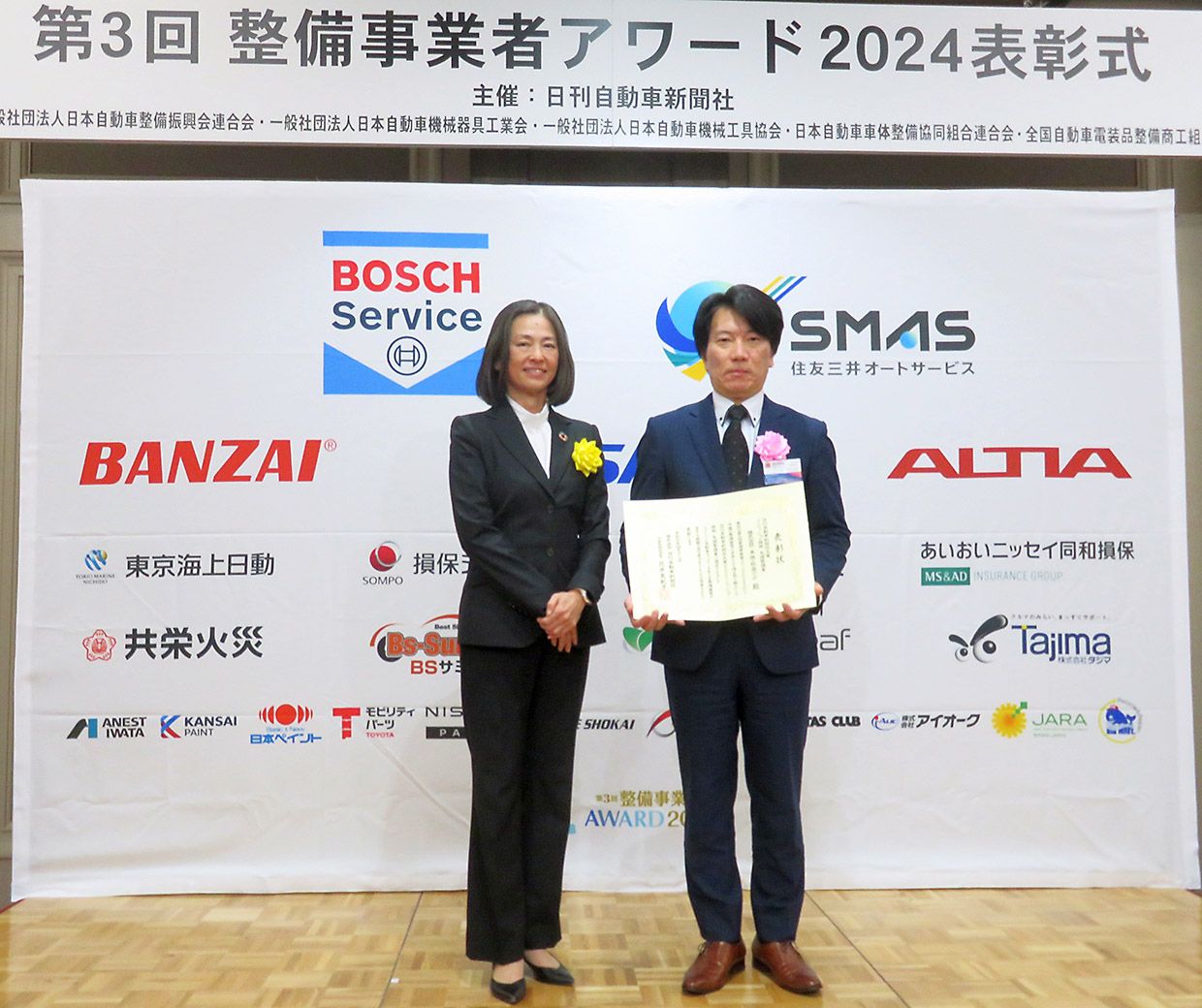 記念撮影に応じる車検・鈑金デポの上松禎知社長(右)と弊社花井社長