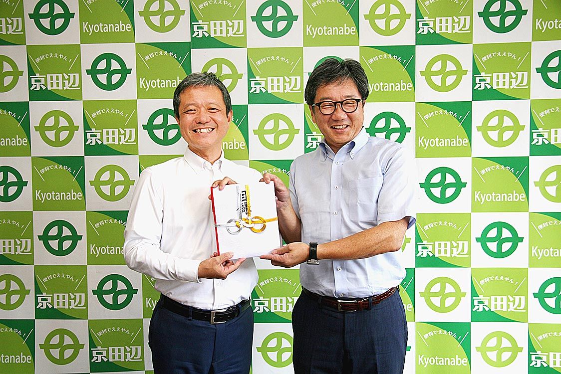 京田辺市での寄付贈呈式。上村崇市長(左)と森松倫取締役