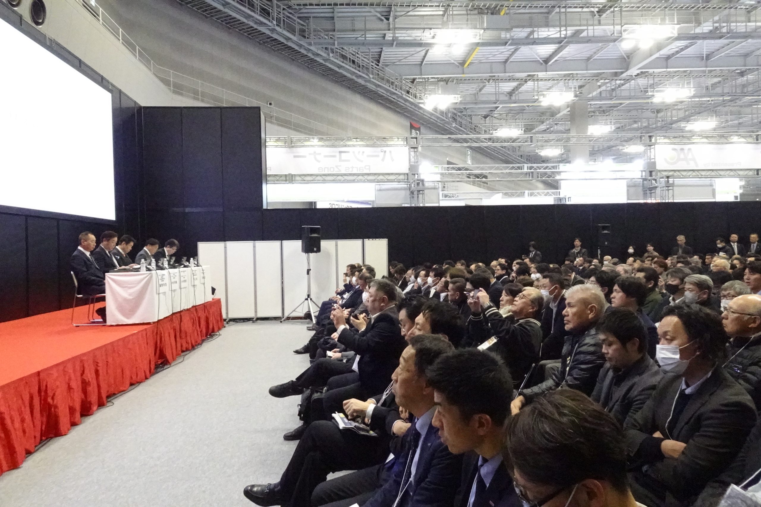 出席者の話を熱心に聞く来場者