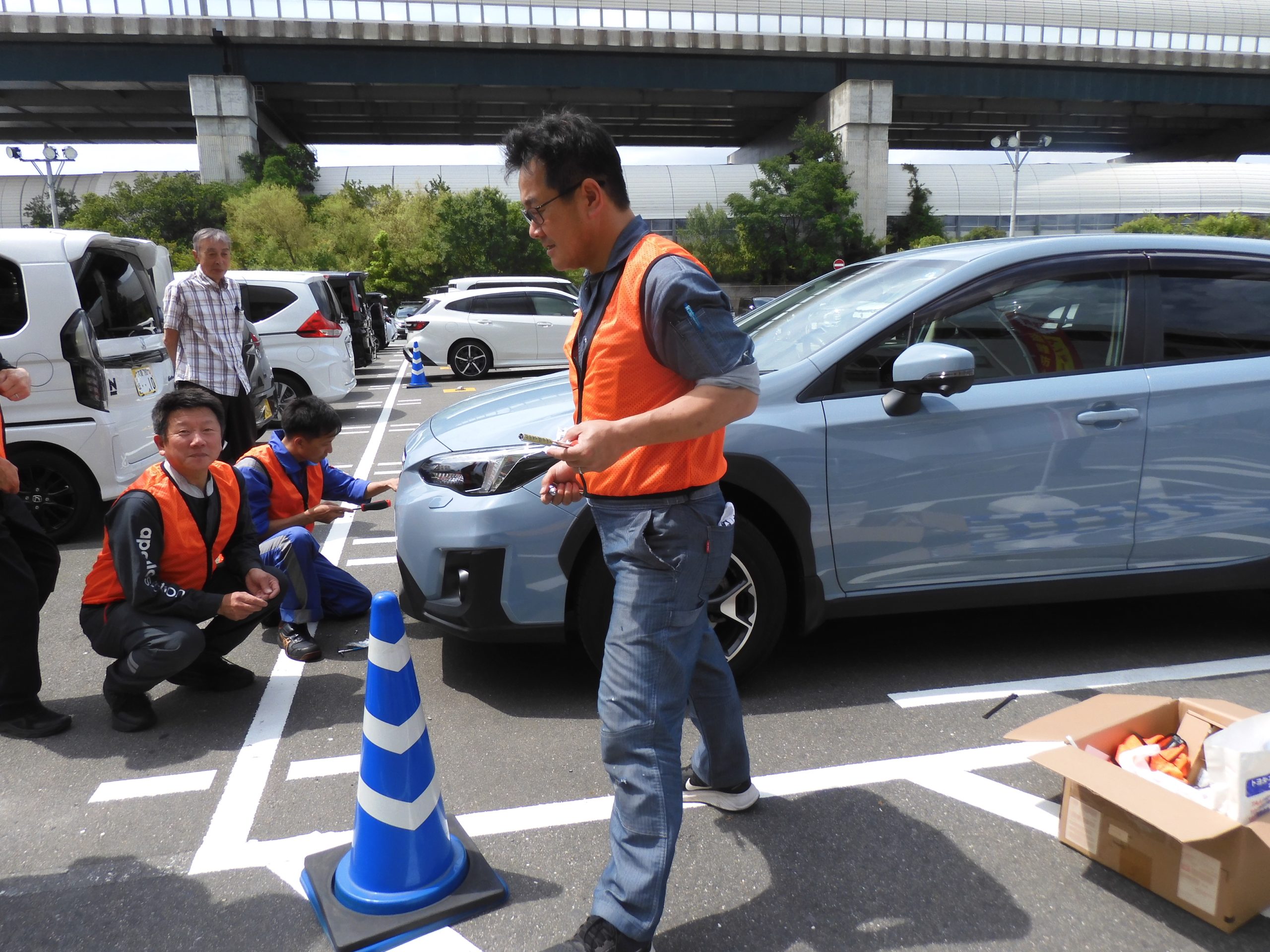 施設の屋外駐車場では、大整振の大東・四条畷自動車整備地区会が取り付けに協力