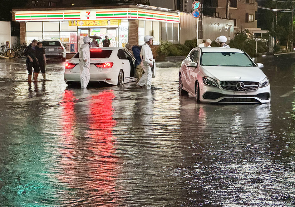 大雨の影響で冠水した道路。13日夜、千葉県市川市にて(時事)