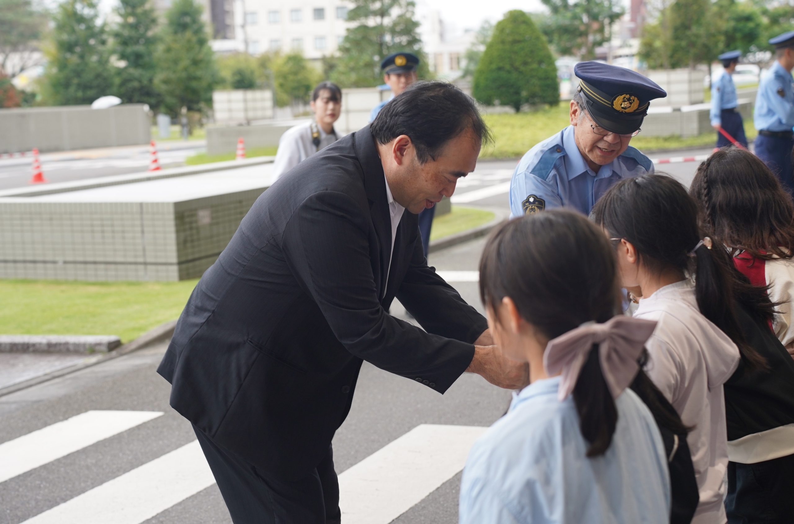 キーホルダーを手渡す新井社長(左から1人目)
