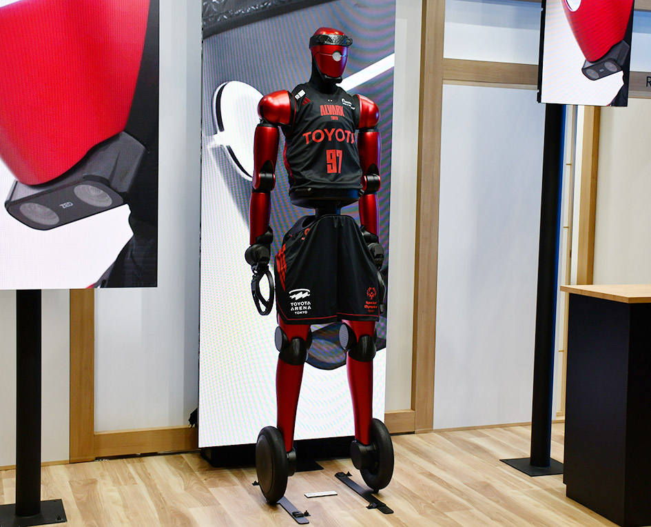 トヨタブースに展示されたのは1体のバスケットボールロボット「CUE7」。Bリーグに所属するプロバスケットボールチーム・アルバルク東京の試合のショータイムで披露しているロボットで、ドリブルやシュートができる。モデルとなる選手の動きを学習させており、シュートは高い確率で成功させているという(JMS)