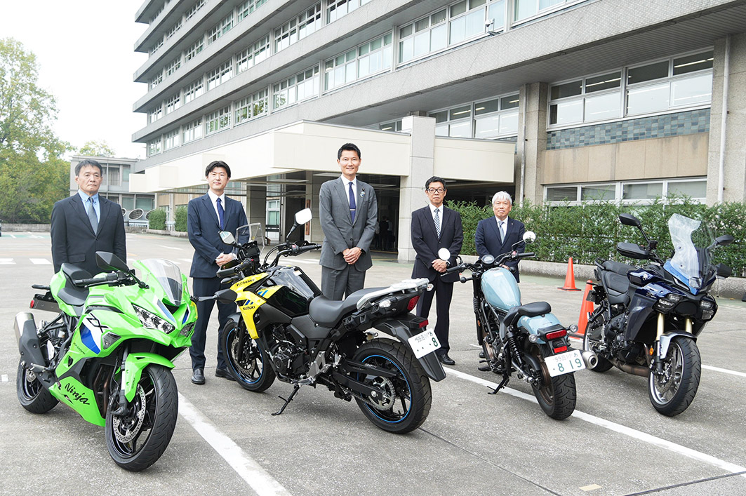 朝日健太郎国土交通副大臣(中央)。展示車両は左からカワサキモータース「ニンジャZX-25RR」、スズキ「Vストローム250」、ホンダ「レブル250 Sエディション Eクラッチ」、ヤマハ「トレーサー9 GT+ Y-AMT」