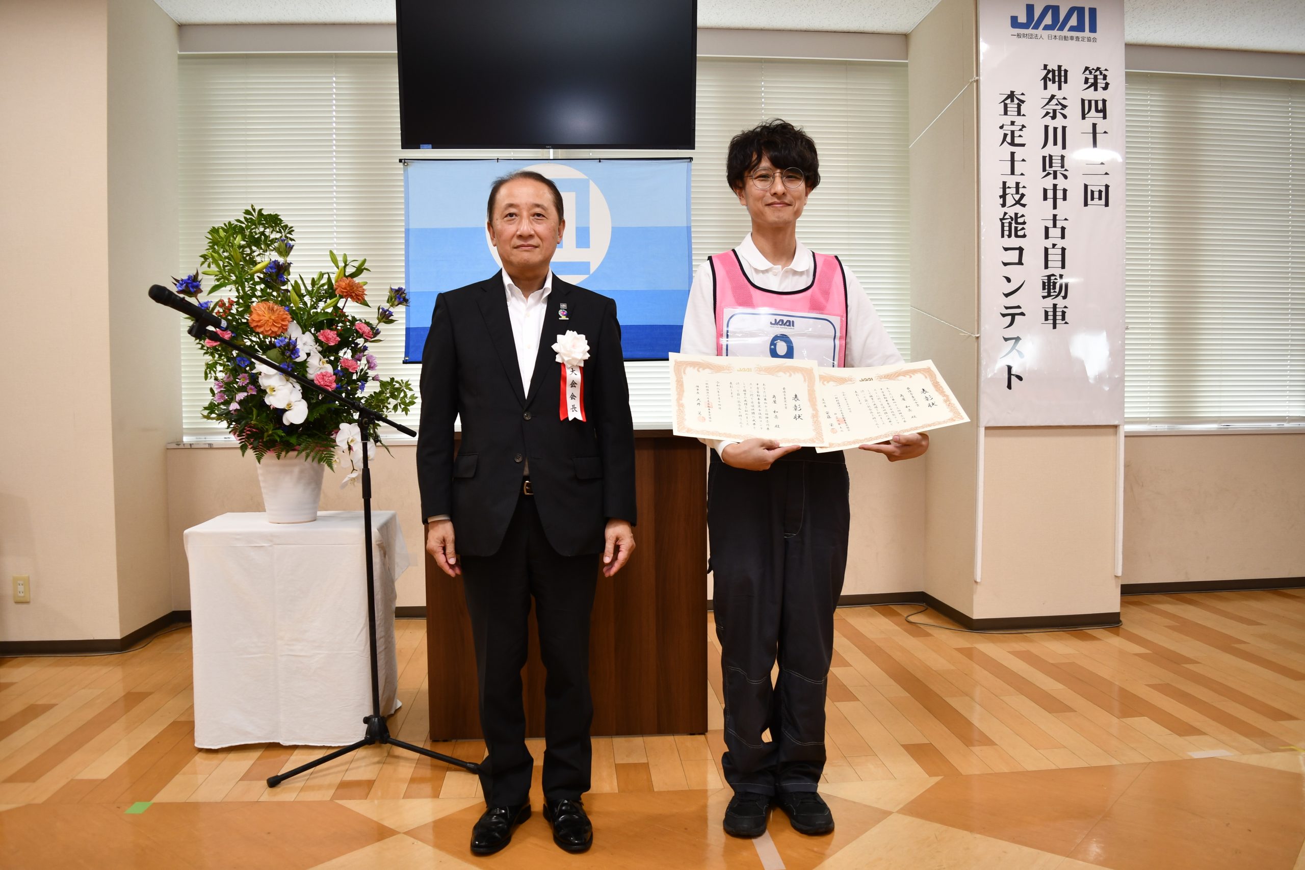 最優秀査定士賞に輝いたウエインズトヨタ神奈川の角屋和亮さん(右)と安藤栄一支所長(左)
